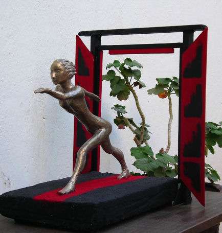 Bronze striding figure on base with red door